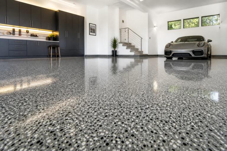 Professionally installed epoxy floor in a Gold Coast residential garage with a light grey decorative flake finish.