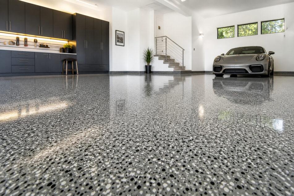Professionally installed epoxy floor in a Gold Coast residential garage with a light grey decorative flake finish.